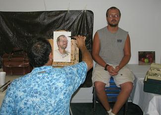 On the second day of the workshop, Artist Tim Tyler demonstrated painting from model Justin Griffith of Clinton. On the first day, he demonstrated painting a still life; that painting can be seen on the right of the photo. (photo by Joyce Hartmann)