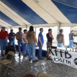 Folks wait in line under the tent during the rain for a Petit Jean Hot Dog and a ice cold pepsi